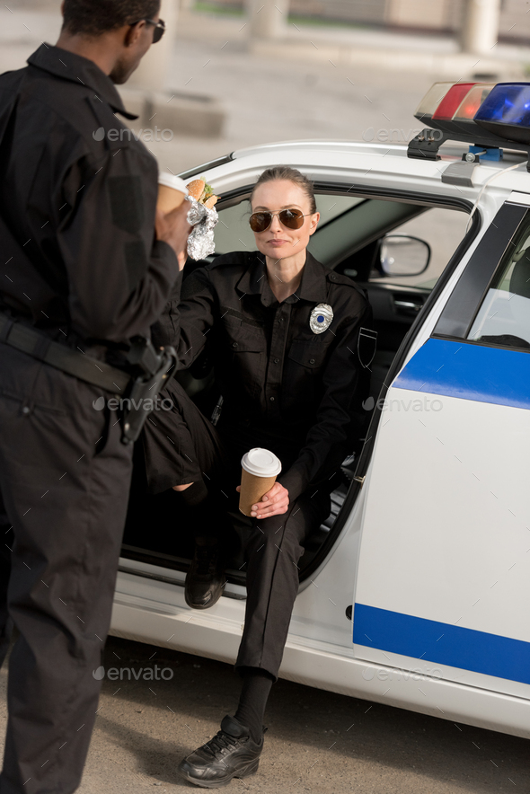 policewoman in sunglasses having lunch with african american partner