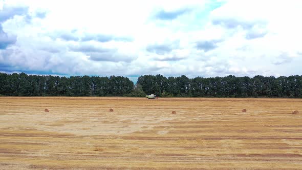 Aerial view on the field and combine working on the natural rural background alt