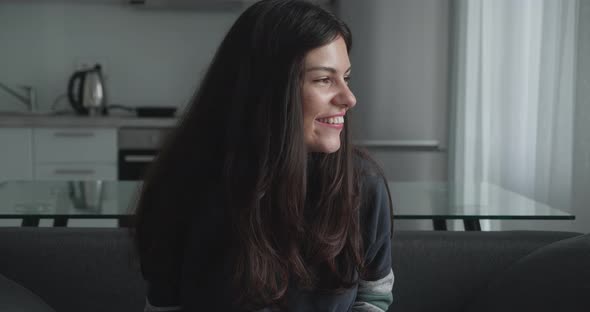 Excited Young Woman Wearing Sitting on Bed at Home Looking Happy After Positive Result From Home alt