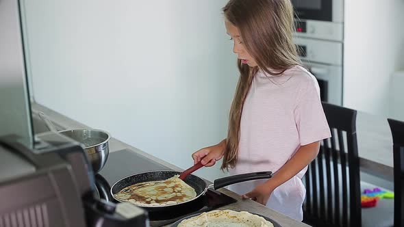 Child Cooking Pancakes in Kitchen