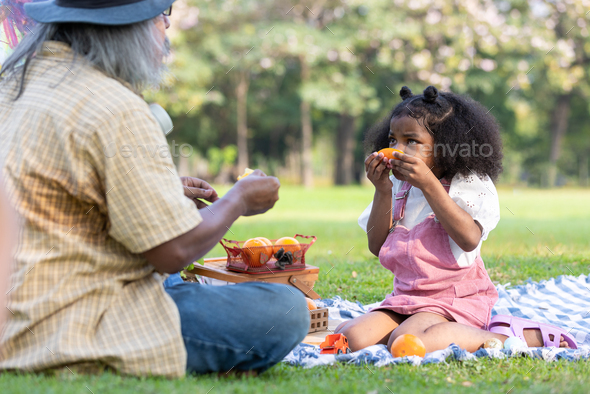 A curly hair children eating orange with be happiness - Stock Photo - Images