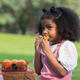 A curly hair children eating orange with be happiness - PhotoDune Item for Sale
