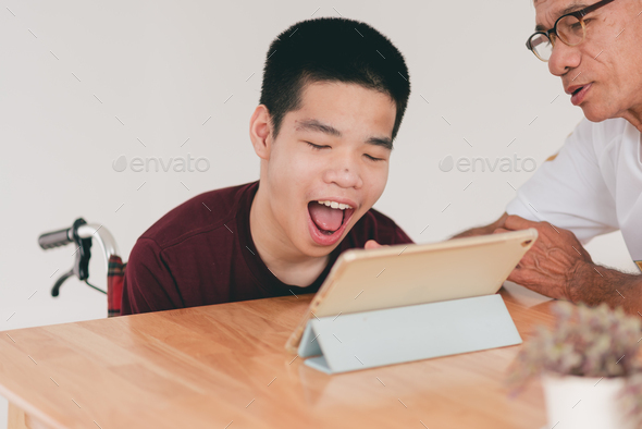 Homeschooling concept by parents of Happy and confidence teenage boy with disability on wheelchair. - Stock Photo - Images