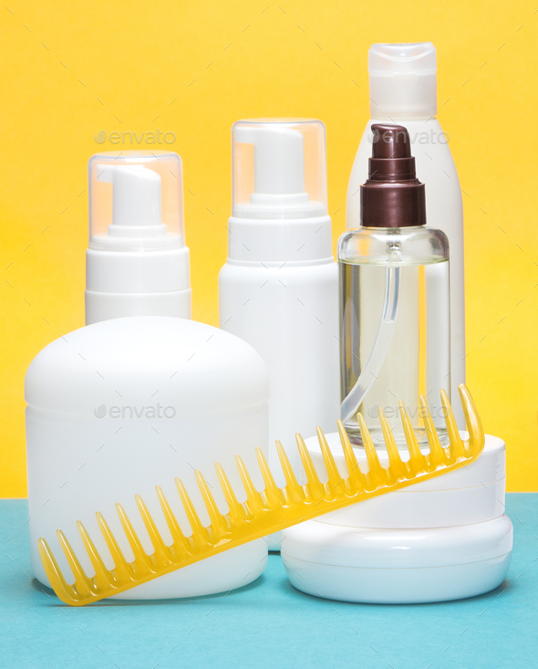 Hair care and styling products with wide tooth comb on blue and yellow background