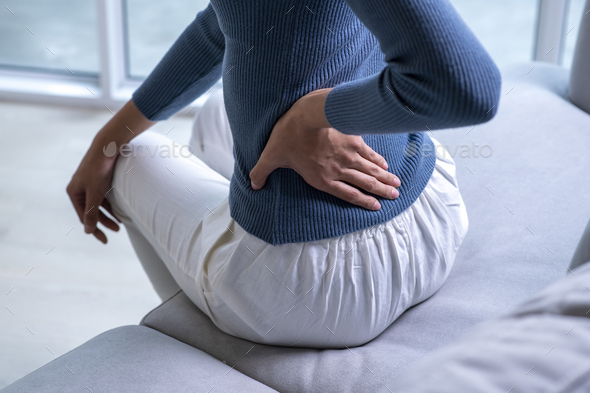 Female with back pain at home - Stock Photo - Images