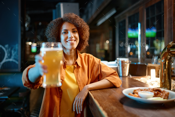 Young woman cheering for favorite team watching match in sports bar