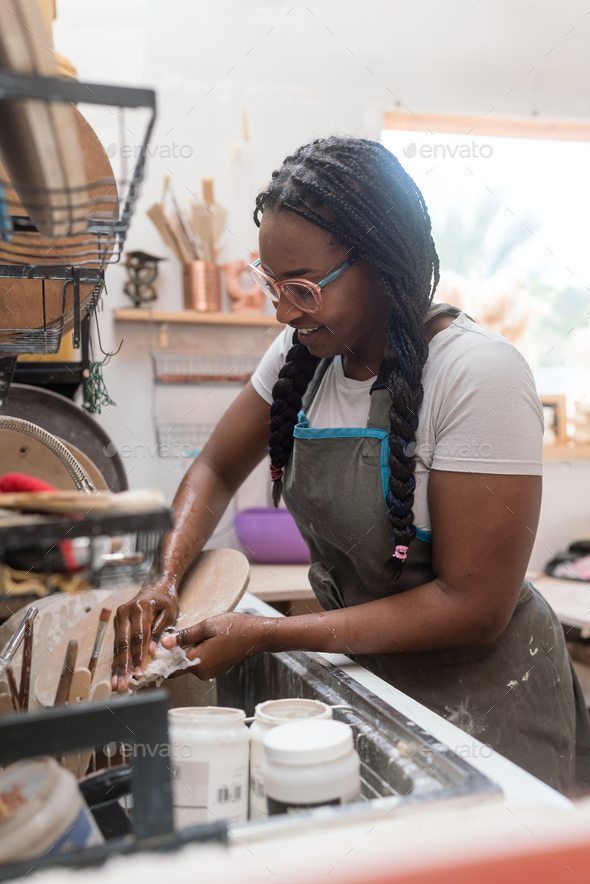 Woman washing her pottery at the ceramics studio Stock Photo by