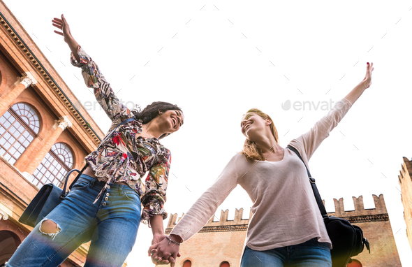 Happy multiracial girlfriends having genuine fun walking in city center - Stock Photo - Images