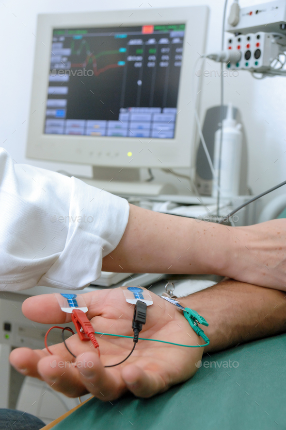 Laboratory test with electrodes in the hand Stock Photo by Graphico_