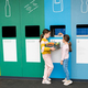 Girls taking out plastic trash in recycling centre. National recycling week. - PhotoDune Item for Sale
