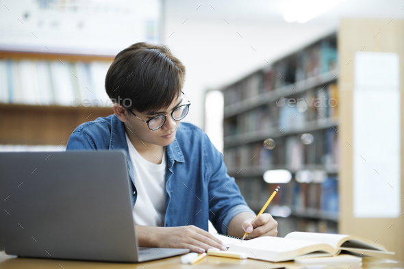 Student studying at library. - Stock Photo - Images