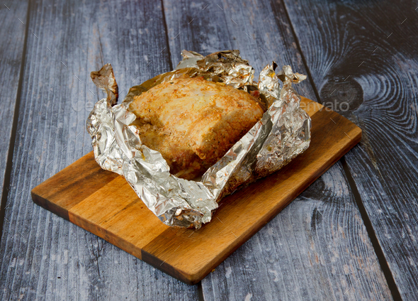 Closeup shot of oven-baked pork roast in tin foil