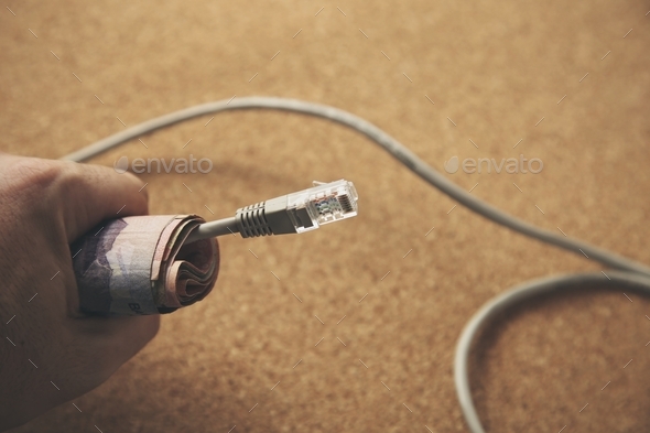 Making money online concept image consisting of human hand, cash and an internet cable