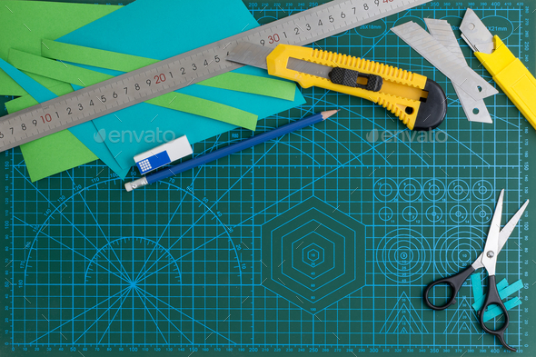 Overhead shot of office supplies of the ruler, cutter, on green cutting ...
