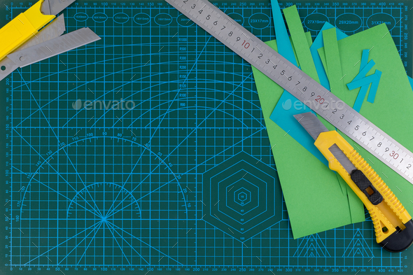 Overhead shot of office supplies of the ruler, cutter, on green cutting ...