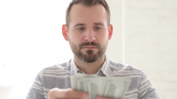 Adult Young Man Counting Dollar Paper Currency alt