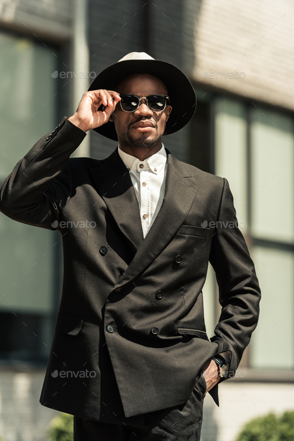 Handsome young african american businessman wearing fedora hat and