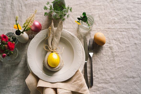Happy Easter. Stylish easter eggs on a napkin with spring flowers on white wooden background - Stock Photo - Images