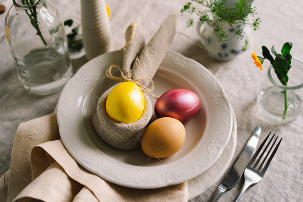 Happy Easter. Stylish easter eggs on a napkin with spring flowers on white wooden background - Stock Photo - Images