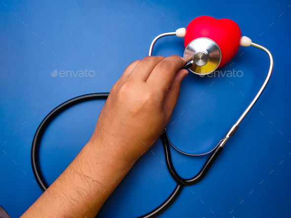 Hand holding statehoscope checking red heart .Healthcare and medical concept. - Stock Photo - Images