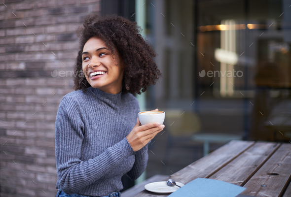 Smiling African American woman looking away, drinking morning coffee in ...