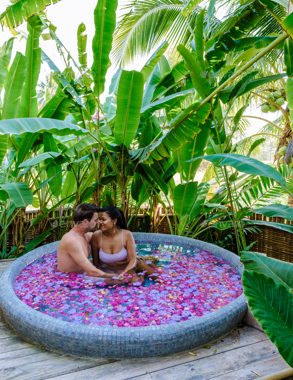 Men and women at a bathtub in the rainforest of Thailand during