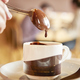 person dunking dripping spoon into cup of hot chocolate - PhotoDune Item for Sale