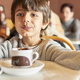 kid eating churros and chocolate on a crowded bar - PhotoDune Item for Sale