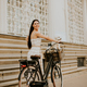 Young woman with white bichon frise dog in the basket of electric bike - PhotoDune Item for Sale