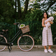 Young woman putting white bichon frise dog in the basket of electric bike - PhotoDune Item for Sale
