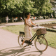 Young woman with white bichon frise dog in the basket of electric bike - PhotoDune Item for Sale