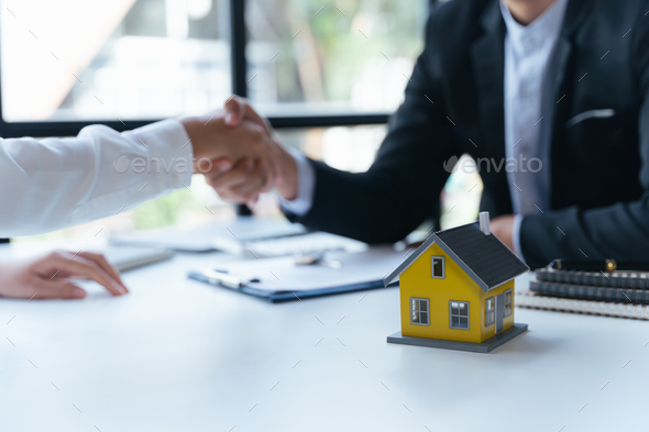 Agent and client shaking hands after signed document and done business deal