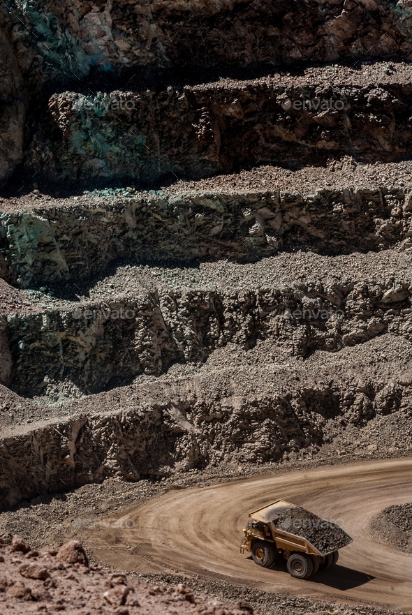 Open rock mine with different layers and a truck carrying rocks Stock ...