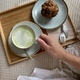 Hand holding cup with matcha latte and muffin - PhotoDune Item for Sale