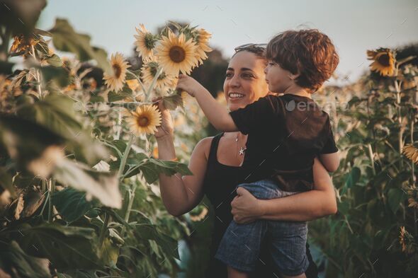Young mom with her son looking at sunflowers at a Pumpkin patch in Bonita Springs, Florida
