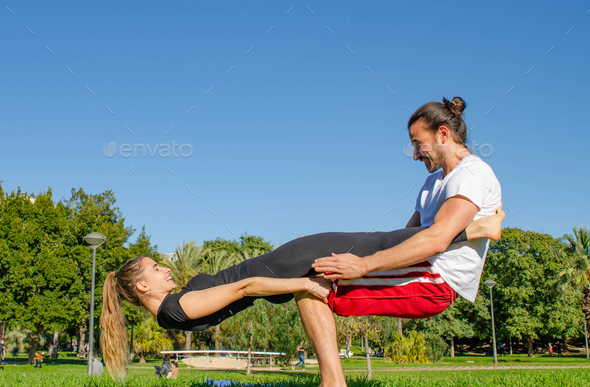 Happy Couple Having Fun Looking Each Other Practicing Acro Yoga Pose at the  Park in Valentin's Day Stock Photo by wirestock