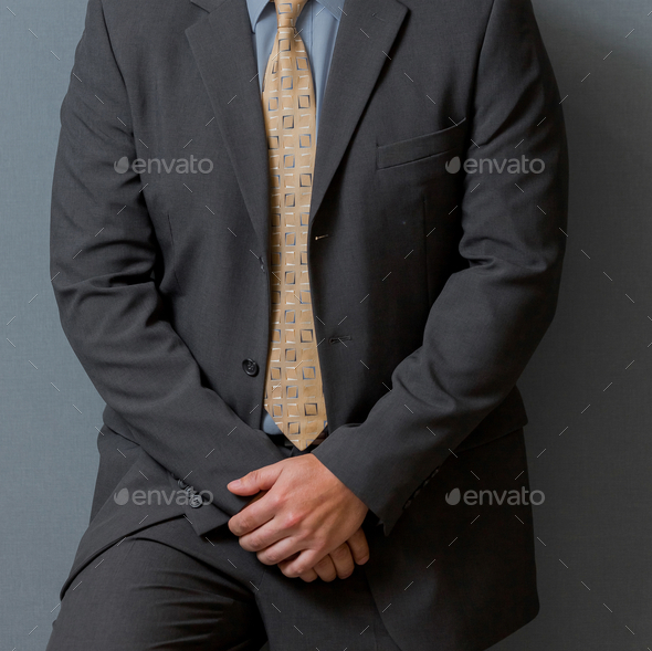 Male In A Classic Gray Suit Holding His Hands And Leaning On A Wall ...