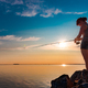 Woman fishing on Fishing rod spinning at sunset background. - PhotoDune Item for Sale