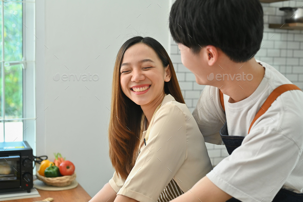 Affectionate asian man and smiling woman preparing homemade pastry, spending time. - Stock Photo - Images