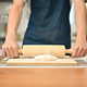 Young man in apron kneading dough with a rolling pin on kitchen table, - PhotoDune Item for Sale