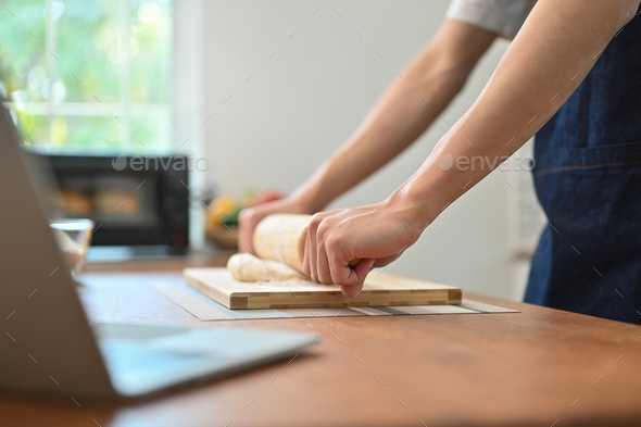 Cropped image of man wearing aprons preparing homemade pastry, kneading dough. - Stock Photo - Images
