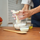 Man wearing aprons hands kneading dough on wooden table, preparing homemade pastry. - PhotoDune Item for Sale