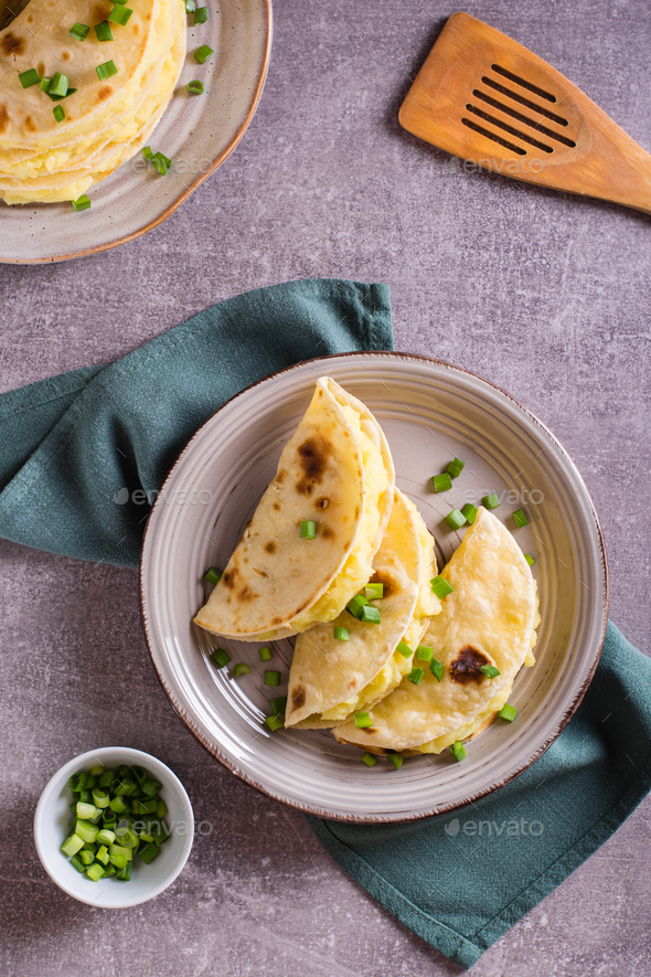 Tortillas stuffed with mashed potatoes and onions on a plate. Top and