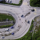 Aerial view of the concrete road leading to the industrial zone. Clip. Cars driving near green - PhotoDune Item for Sale