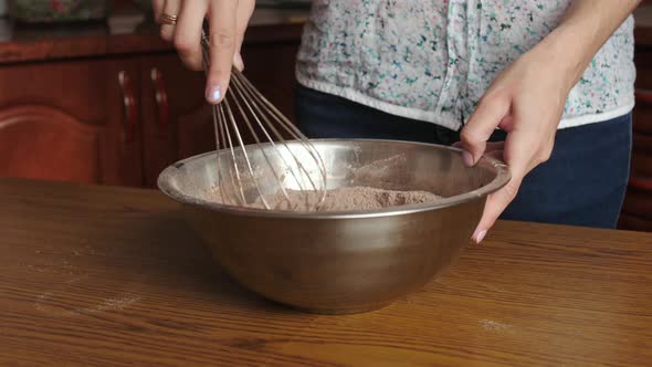 Woman whisking together the sugar, flour and cocoa powder alt