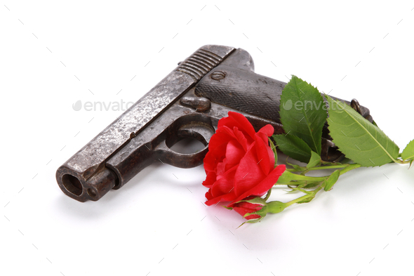 Closeup shot of a gun and a red rose isolated on a white background