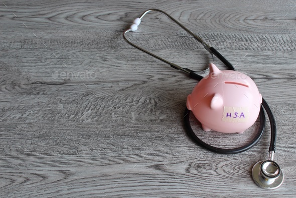 HSA or Health Savings Account text on piggy bank and stethoscope