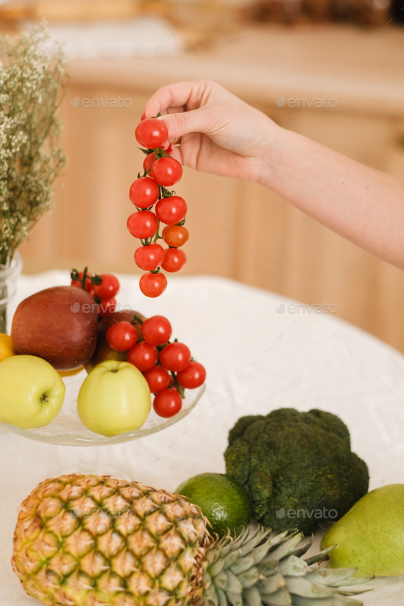 Fresh Fruits And Vegetables On Kitchen Table Stock Photo by