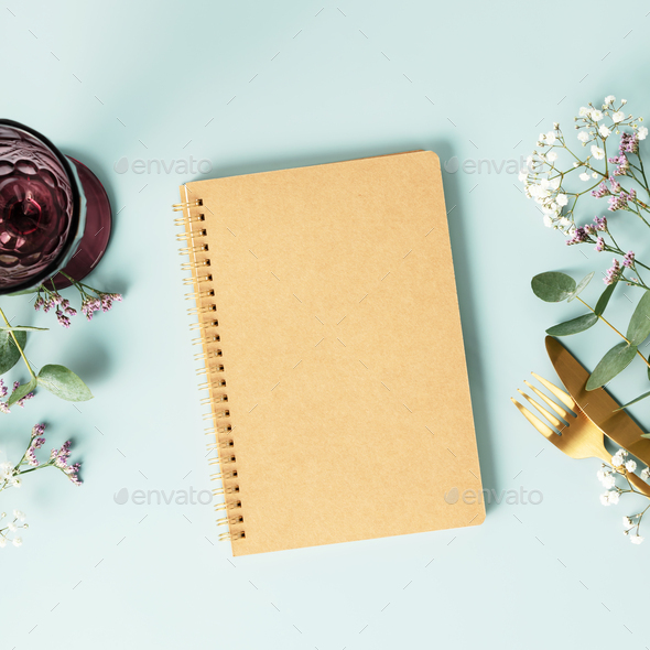 Notebook and table decorations on blue background. Flat lay top view copy space mockup - Stock Photo - Images