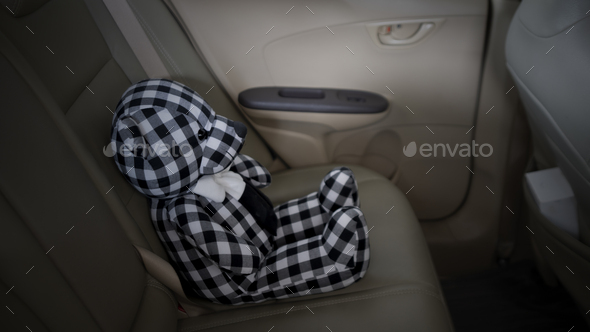 lonely teddy bear sitting alone in the car for created postcard of international missing children.